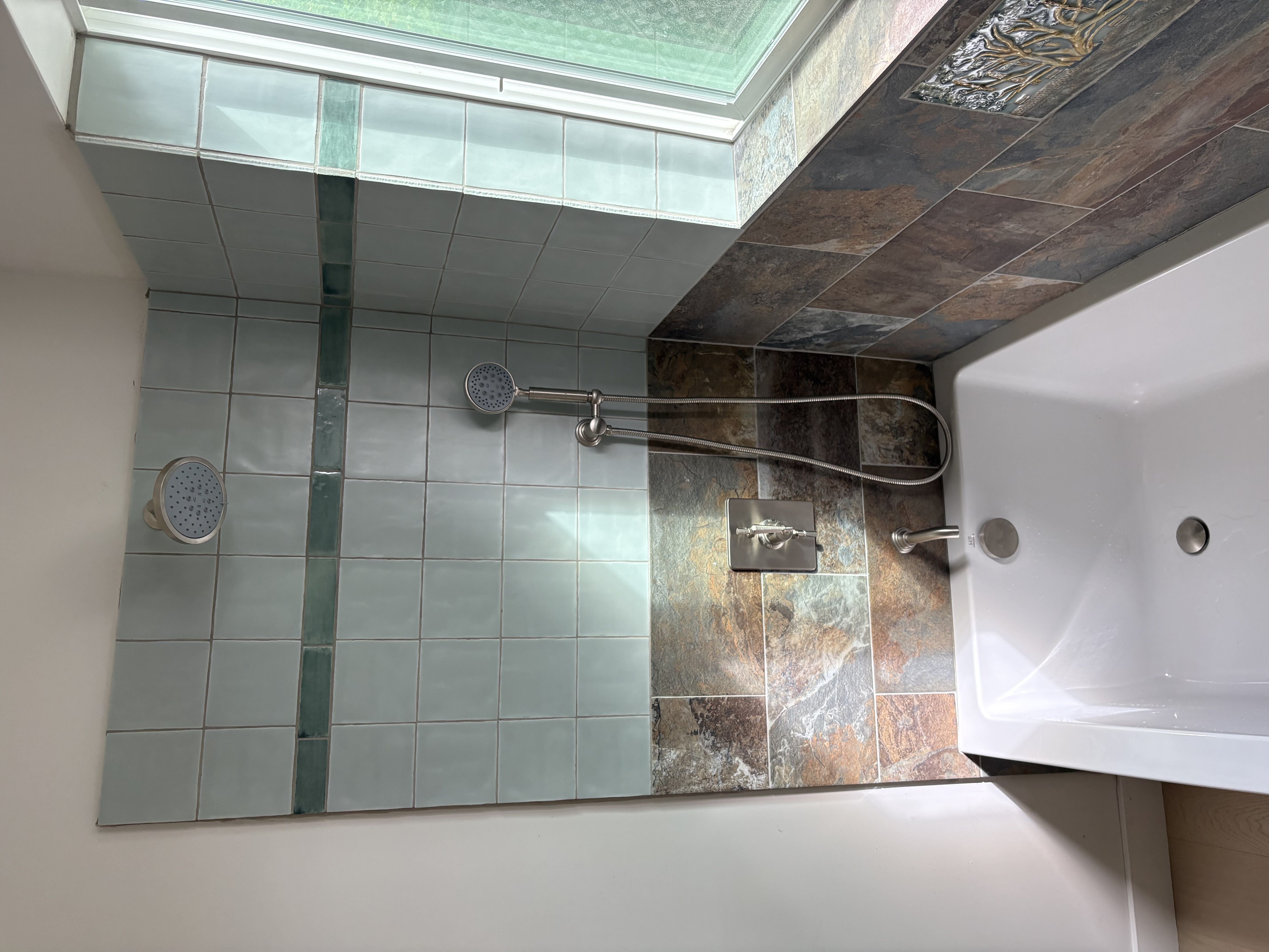 Bathroom remodel with dual-head shower, slate tile, and soaking tub